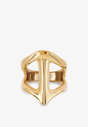 Anillo de tono dorado con forma de casco estilizado de caballero medieval, con aberturas para los ojos y superficie lisa y pulida.