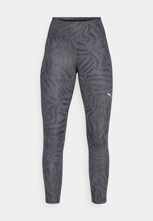 Leggings a vita alta in grigio scuro con un sottile motivo a strisce zebra. Realizzati in tessuto elasticizzato, presentano un logo sulla parte inferiore della gamba.
