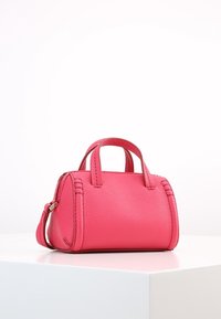 Bolso de mano de piel rosa con dos asas cortas, forma redondeada, acabado texturizado y costuras decorativas en los laterales. Correa de hombro ajustable.