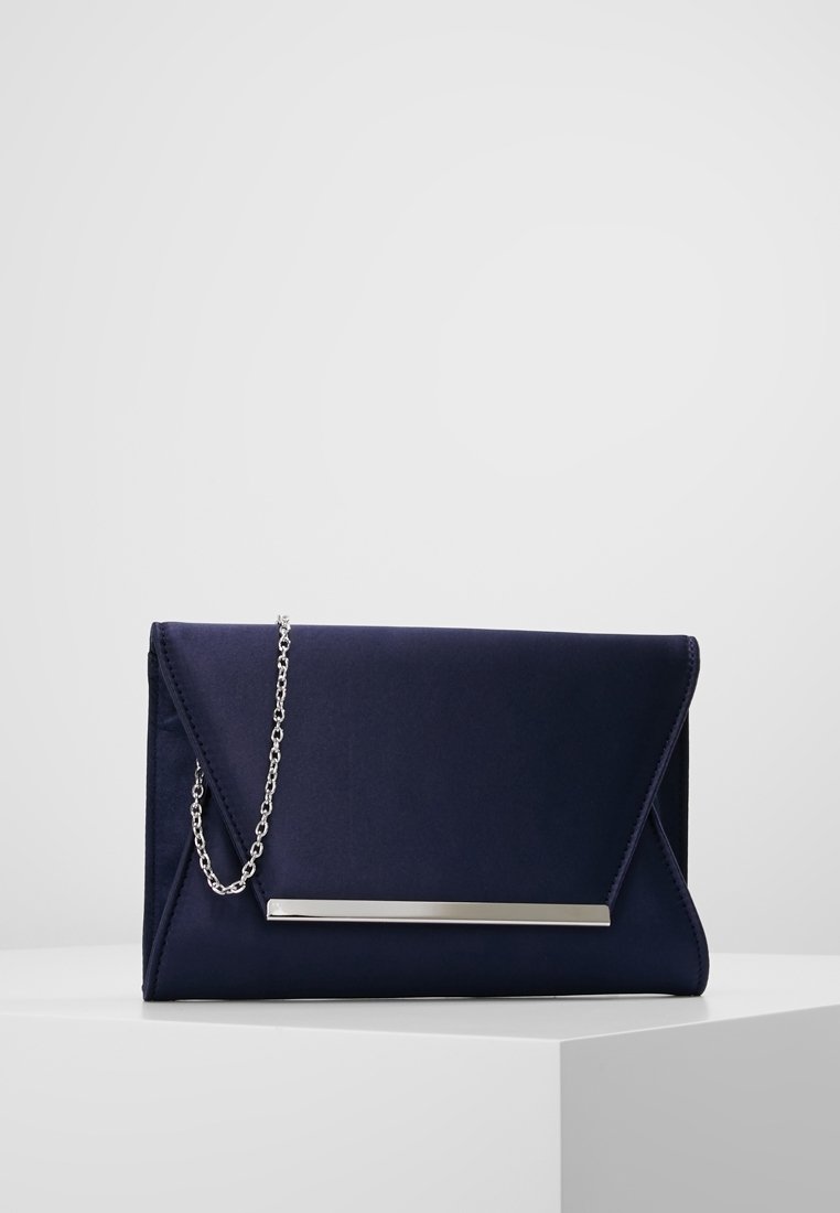 Pochette en satin bleu marine avec une bandoulière chaîne argentée, présentant un design élégant et angulaire ainsi qu'un accent métallique poli à l'avant.