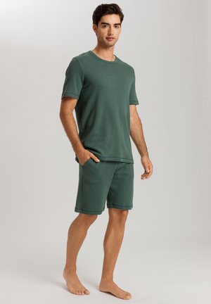 Green cotton short-sleeve t-shirt with ribbed texture, paired with matching shorts featuring pockets and similar material.