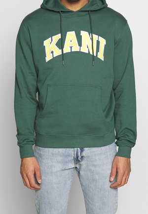 Sudadera verde hecha de una tela suave, con un bolsillo tipo canguro, cordones ajustables y un atrevido texto en letras amarillas y blancas que dice "KANI".
