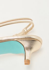Sandalini con tacco alto in metallo dorato, dotati di due fascette sottili e con una soletta turchese e una base del tacco texturizzata.