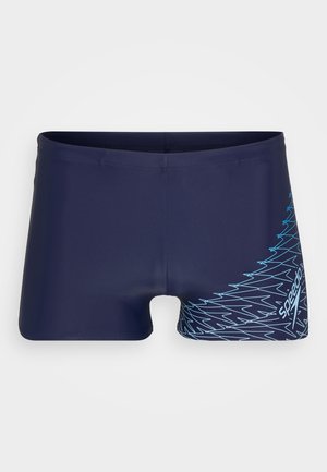 Marineblaue Schwimmshorts aus elastischem Material, mit einem blauen geometrischen Muster auf einer Seite und einem figurbetonten Design.
