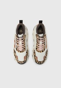 Ζευγάρι λευκά αθλητικά παπούτσια με ροζ κορδόνια και λεπτομέρειες με λεοπάρ μοτίβο, εμφανιζόμενα από πάνω σε απλό ανοιχτό φόντο.