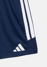 Σκούρο μπλε αθλητικά σορτς με λευκές ρίγες και την εμβληματική τριπλή ρίγα. Κατασκευασμένα από αναπνεύσιμο ύφασμα, διαθέτουν πλέγμα και πλαϊνή τσέπη.