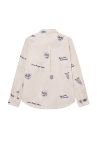 Long-sleeve shirt in cream fabric featuring navy blue printed designs, including hearts, a globe, and pennants, with a button-down collar.