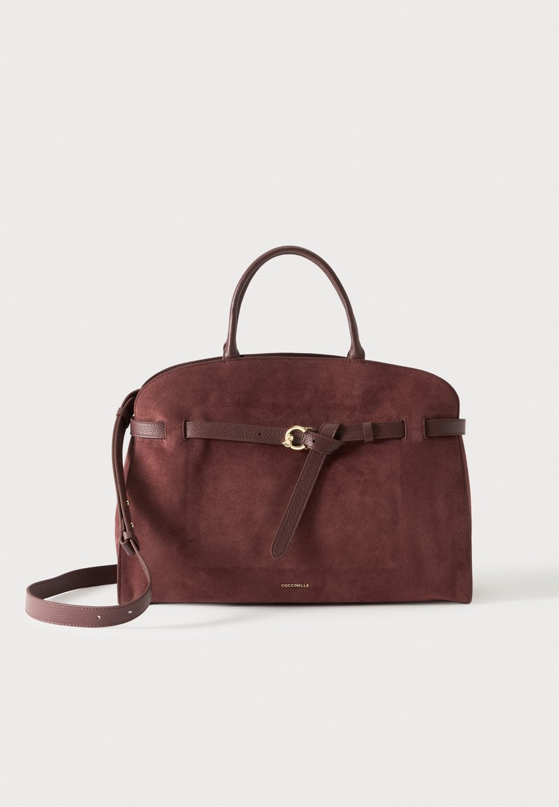 Grand sac à main en daim marron avec poignées arrondies, bandoulière réglable et ceinture décorative avec boucle dorée à l’avant.