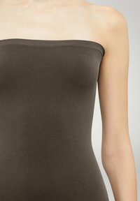 Brauner trägerloser Top aus weichem, dehnbarem Stoff. Glatte Textur, figurbetontes Design und gerader Ausschnitt betonen einen minimalistischen Stil.