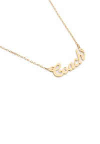 Gouden ketting met een hanger waarin 'Coach' in cursieve letters is gespeld, met een gepolijste afwerking en een sterdetail op de letter 'h'.