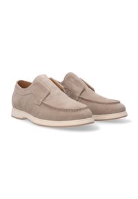 Beżowe zamszowe buty typu slip-on z okrągłym noskiem, minimalnym przeszyciem i beżową gumową podeszwą. Charakteryzują się dużą pętlą ułatwiającą zakładanie i zdejmowanie.