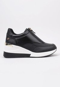 Zapatillas negras con una parte superior de cuero texturizado, diseño sin cordones, acento en dorado y una suela intermedia gruesa blanca con suela exterior negra.