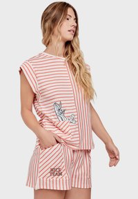 Set di abbigliamento lounge a righe in corallo e bianco, composto da una maglietta oversize con tasca che presenta un personaggio dei cartoni animati e pantaloni corti abbinati con testo ricamato.