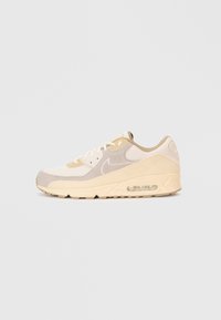Béžové a krémové tenisky Nike Air Max s viditeľnou vzduchovou podložkou a zmesou semišu a sieťoviny, vystavené na jednoduchom pozadí.