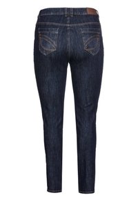 Jeans de mezclilla azul oscuro con una silueta ajustada, que cuentan con dos bolsillos traseros, costuras visibles y una etiqueta marrón en la cinturilla.