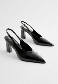 Musta patentoitu nahka slingback-korkokengät, joissa on terävä kärki ja läpinäkyvä lohkokorko. Luja pinta ja tyylikäs muotoilu.