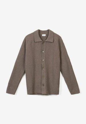 Brun ribbad kofta med krage, knäppning fram och långa ärmar. Tyget har en strukturerad väv och en avslappnad passform.