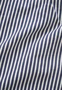 Tissu rayé vertical bleu et blanc avec plis et texture visibles.