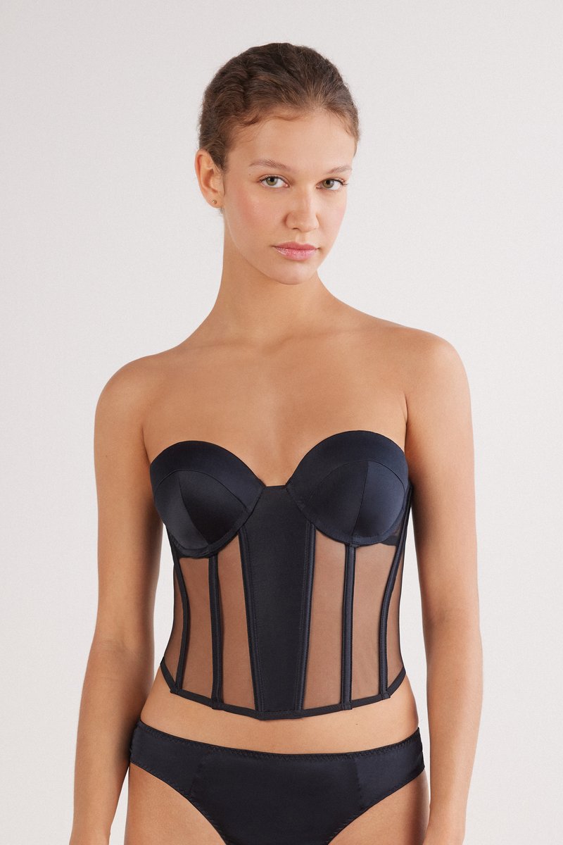 Black satin corset top with structured cups and sheer side panels. Features vertical boning and a fitted silhouette, paired with matching briefs.