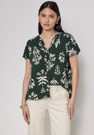 Blusa verde floreale in tessuto leggero, con motivi vegetali color crema, colletto e maniche corte. Design con bottoni.