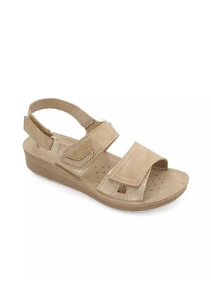 Sandalo beige con cinturino alla caviglia regolabile e due cinturini in velcro. Presenta perforazioni sulla soletta e una suola a zeppa. Texture in morbido camoscio.