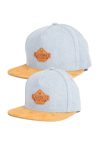 Two snapback caps with light blue denim fabric and yellow suede peaks, featuring a brown leather logo patch on the front.