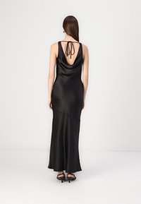 Black satin gown with a cowl back and tie detail, featuring a fitted silhouette that flows into a slightly flared hem.