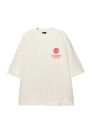 T-shirt crème à manches courtes, col rond, avec un graphisme circulaire rouge et le texte "Culture Alternative" sur la poitrine gauche. Texture douce.