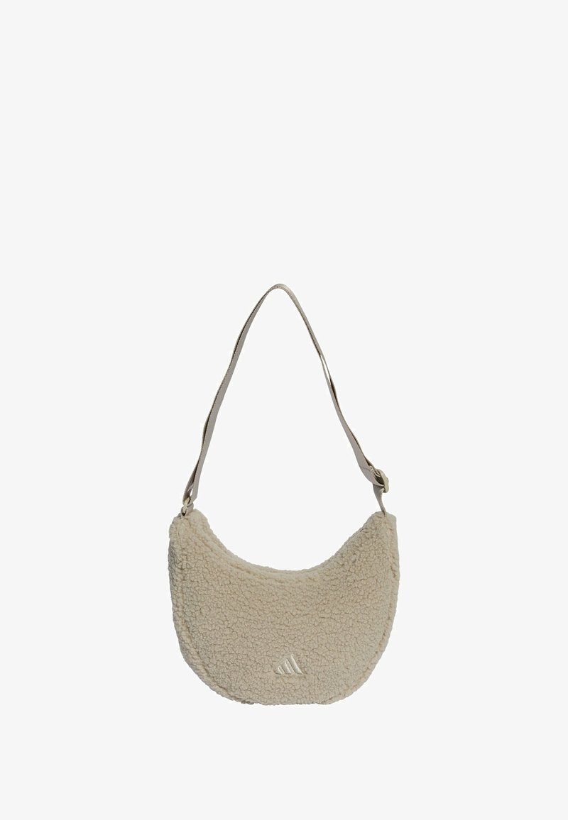 Béžová kožušinová taška na rameno s oblým tvarom, so béžovým ramenným popruhom a malým embosovaným logom na prednej strane.