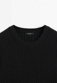 Mustakudottu neulepusero, jossa on teksturoitu kuosi, pyöreä kaula-aukko ja resorit hihoissa. Tunnus näkyvissä kauluksessa.