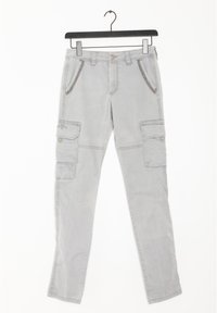 Ljusgrå cargo-byxor med nitar på frampocket och knäppta sidofickor, hängande på en svart hanger mot vit bakgrund.