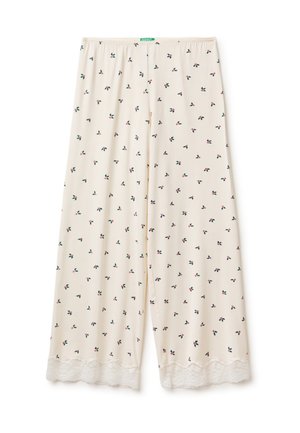 Pantalones beige claro con un estampado floral que presenta pequeños diseños en rojo y verde, adornados con ribete de encaje blanco en la parte inferior. Cintura elástica.