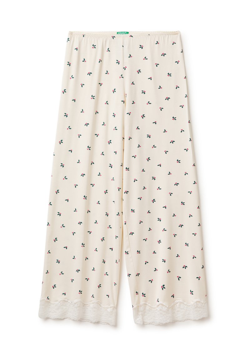Světlé béžové kalhoty s květinovým vzorem obsahujícím malé červené a zelené motivy, doplněné bílou krajkou na spodním lemu. Elastický pas.