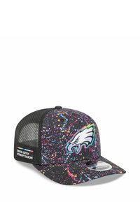 Casquette noire avec un design éclaboussé coloré, arborant un logo en broderie d'aigle à l'avant et des côtés en mesh. Inclut une étiquette "Crucial Catch".