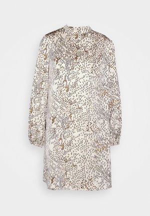 Haljina dugih rukava, visokog ovratnika boje bež s apstraktnim smešnim i crnim točkastim uzorkom, slobodnog kroja i lagano nabranim manžetama.