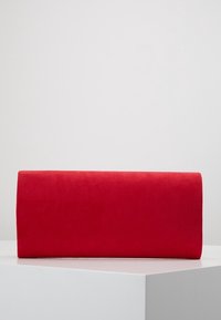 Clutch cilindrico rosso realizzato in morbido suede. Tessuto liscio senza hardware visibili o motivi. Finitura lucida.