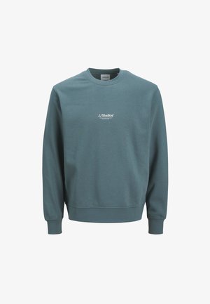 Teal mikina z mäkkého materiálu. Má okrúhly výstrih a dlhé rukávy. Logo "JJ Studios" potlačené bielou farbou na hrudi.