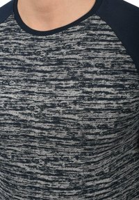 Marineblå og gråstripet kortermet t-skjorte med rund hals, med et teksturert mønster i varierende tykkelser over stoffet.