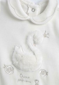 Body in cotone bianco con un design di cigno coccoloso, dettagli in peluche e fiori ricamati, completato da un colletto ondulato e chiusura a pressione.