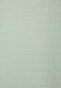 Strukturierter Stoff in einem hellen Mintgrün mit einem geometrischen Muster und einer leicht erhabenen Oberfläche für zusätzliche Tiefe.