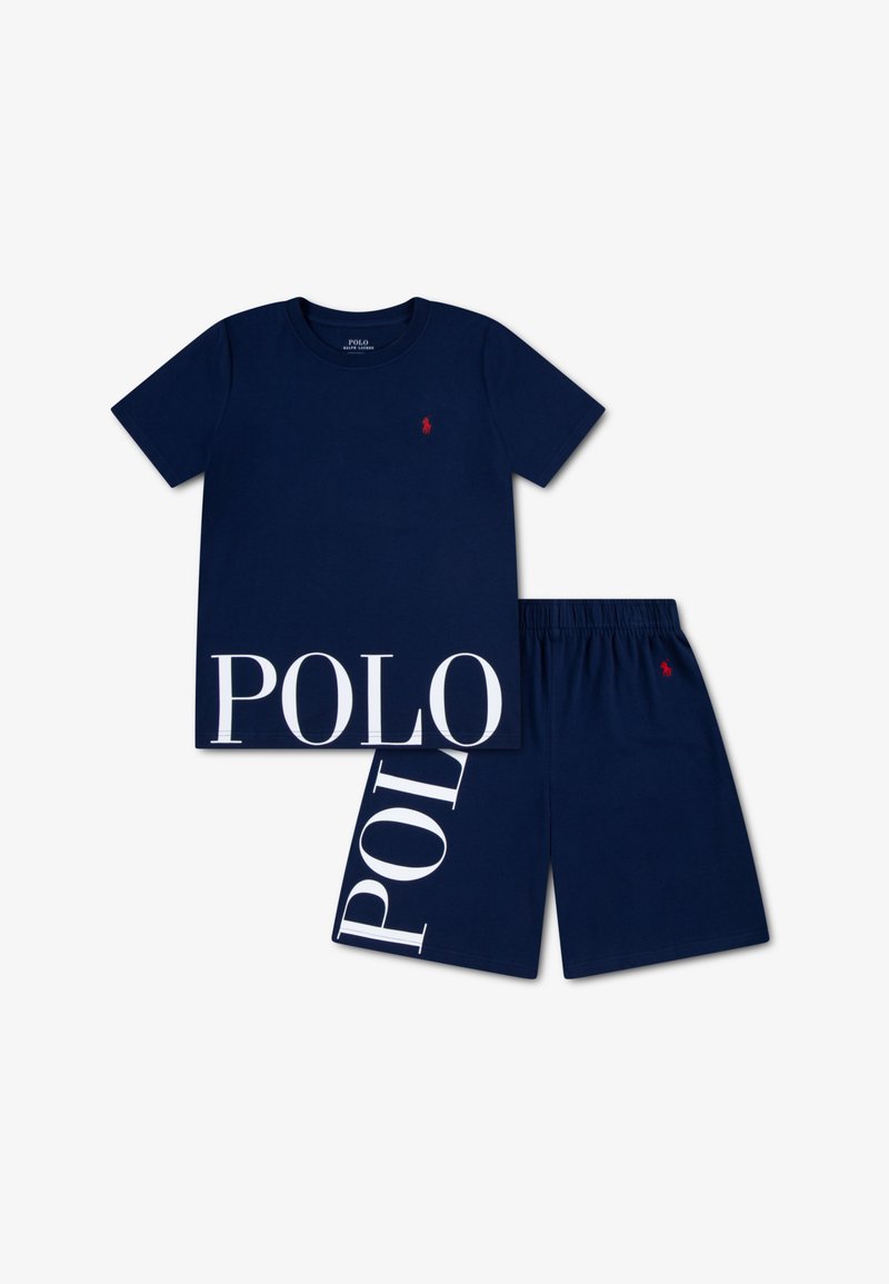 Μπλε βαμβακερό T-shirt με κόκκινο λογότυπο και λευκά γράμματα "POLO" στο τελείωμα. Συνδυάζεται με ταιριαστά μπλε σορτς με παρόμοιο σχέδιο.