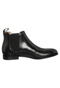 Botín Chelsea de cuero negro con panel lateral elástico, tirador en el talón, tacón bajo y detalle de brogue en la punta y los bordes.