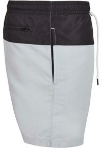 Shorts pour hommes en gris clair et noir, fabriqués en tissu léger ; dotés d'une taille élastique, d'un cordon de serrage et d'une poche zippée.