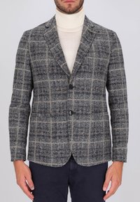 Blazer a quadri grigi con rever a punta, due bottoni e una tasca sul petto. Tessuto in misto lana con texture, caratterizzato da accenti in beige e navy.