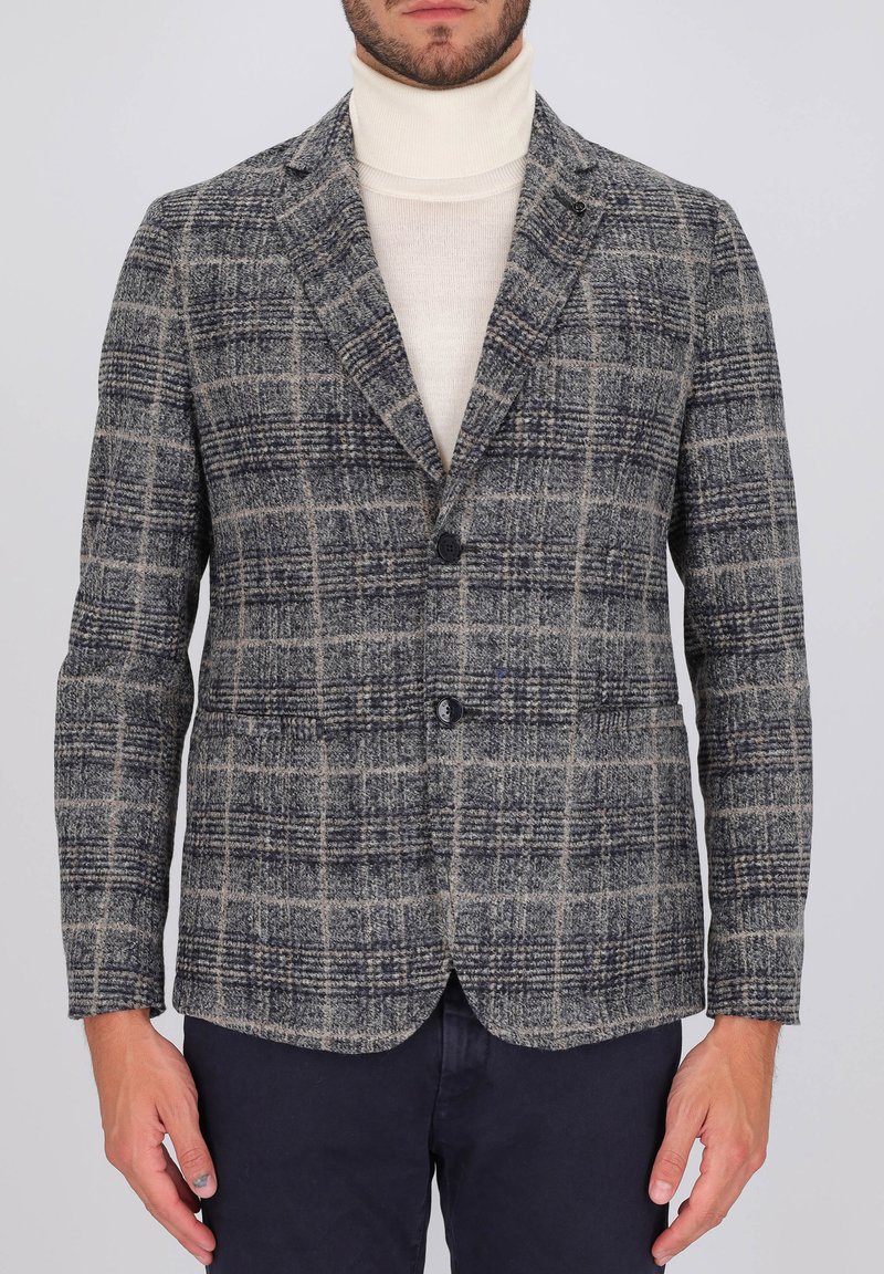 Blazer a quadri grigi con rever a punta, due bottoni e una tasca sul petto. Tessuto in misto lana con texture, caratterizzato da accenti in beige e navy.