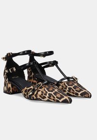 Zapatos de tacón bloque con estampado de leopardo, punta afilada, correas de cuero negro y acentos de hardware dorado. Tejido texturizado con un acabado suave.