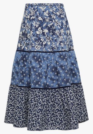 Blå lagdelt nederdel med tre blomster mønstre: store hvide blomster øverst, små hvide blomster i midten og hvide vinranker på mørkeblå forneden.