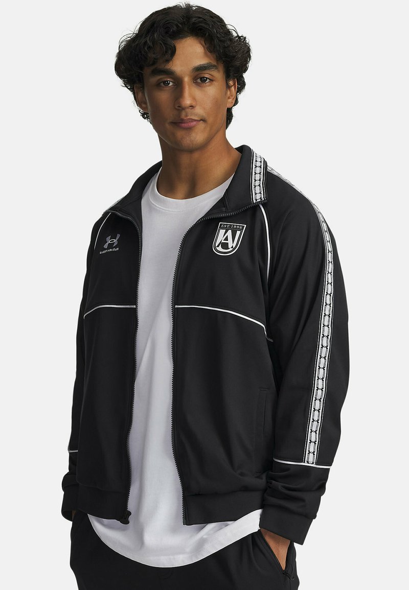 Black athletic jacket with white accents and side stripes. Features a zip front, stand collar, and embroidered logo on the chest.