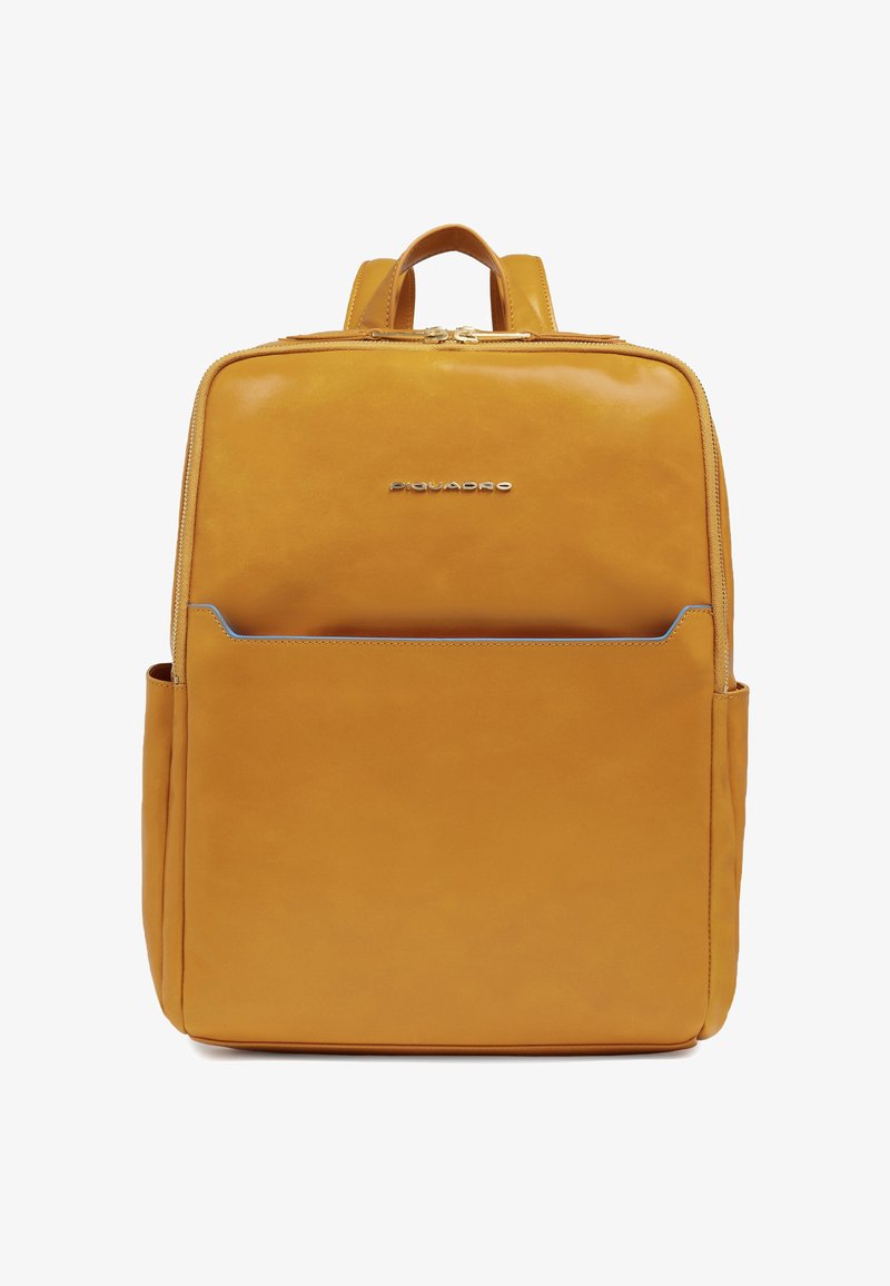 Sac à dos carré en cuir jaune moutarde avec une poche avant, fermeture à double fermeture éclair, poignée supérieure et logo de la marque centré sur le panneau avant supérieur.