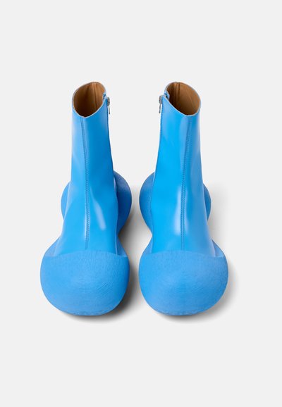 Stivaletti blu alla caviglia con finitura lucida, caratterizzati da punta tonda, suola texturizzata e chiusura con zip sul retro per un facile indossamento.
